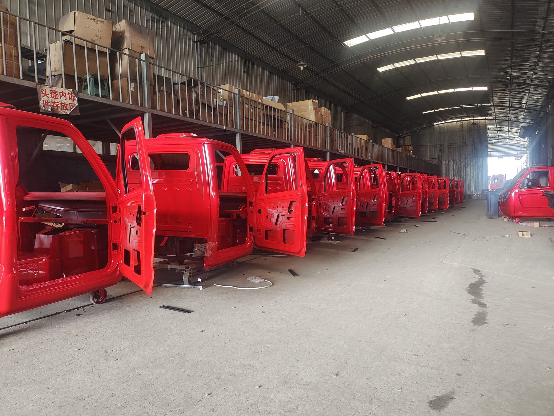 Red cabin bodies lined up in the workshop for assembly