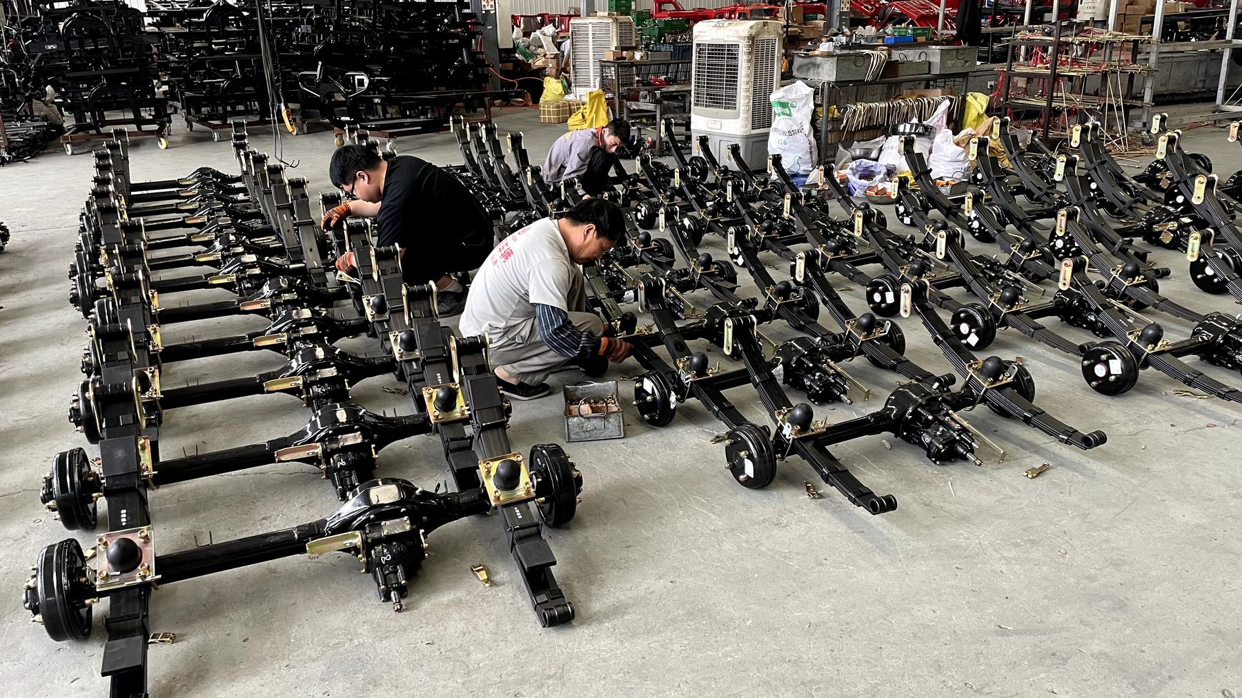 Workers assembling tricycle chassis components