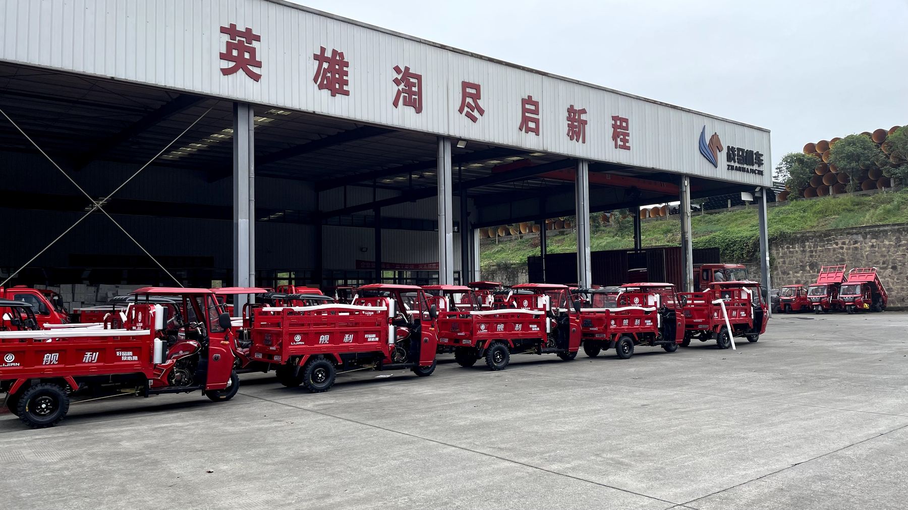 Rows of red cargo tricycles outside the factory